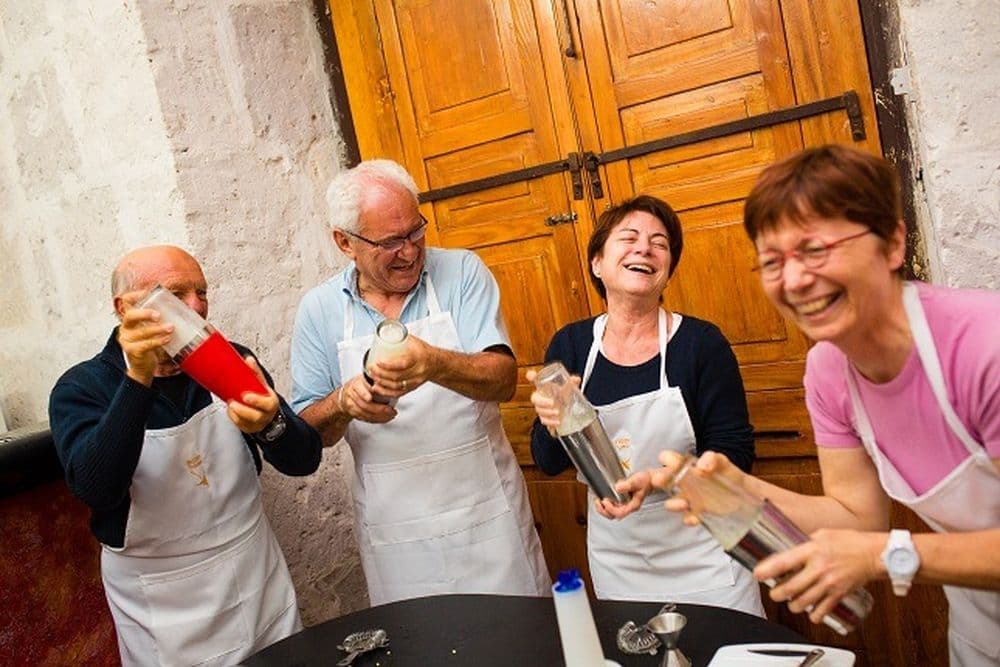 Bei einem Kochkurs mixen Gäste einen Cocktail und lachen sich kaputt. Versuche es auch einmal und lebe wie die Einheimischen auf deiner Südamerika Reise